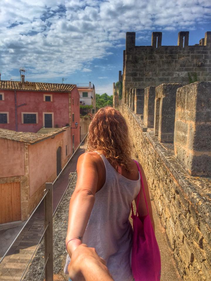 Anita walks along the city walls in Alcudia Mallorca. 
